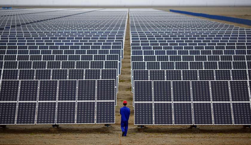 A worker inspects solar panels at a solar farm in Dunhuang, 950km northwest of Lanzhou, Gansu Province