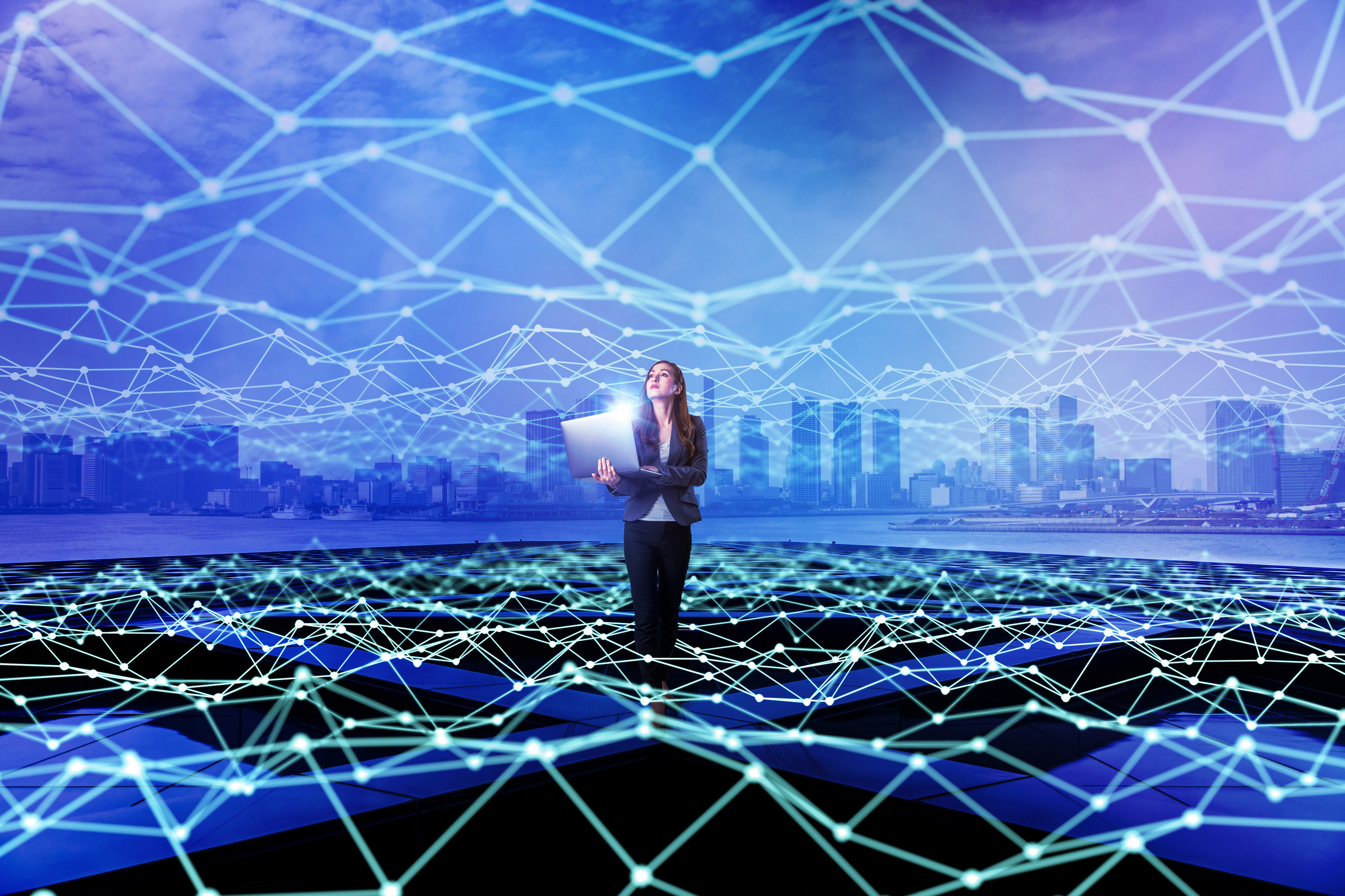 Young woman standing with laptop PC and mesh communication network concept. Internet of Things. Smart city. Information Communication Technology.